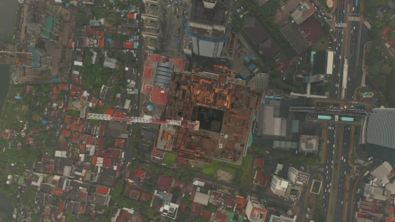 Aerial Birds Eye Overhead Top Down View rotating and moving away from the top of a skyscraper under construction