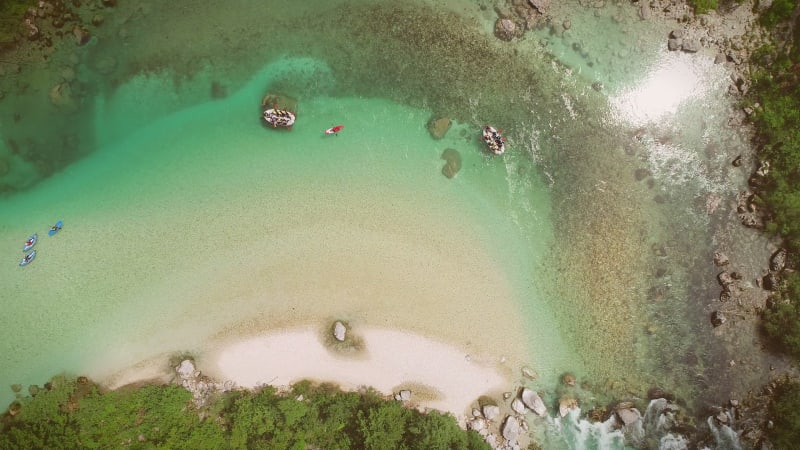 Aerial view of people doing rafting surrounded by rocks.