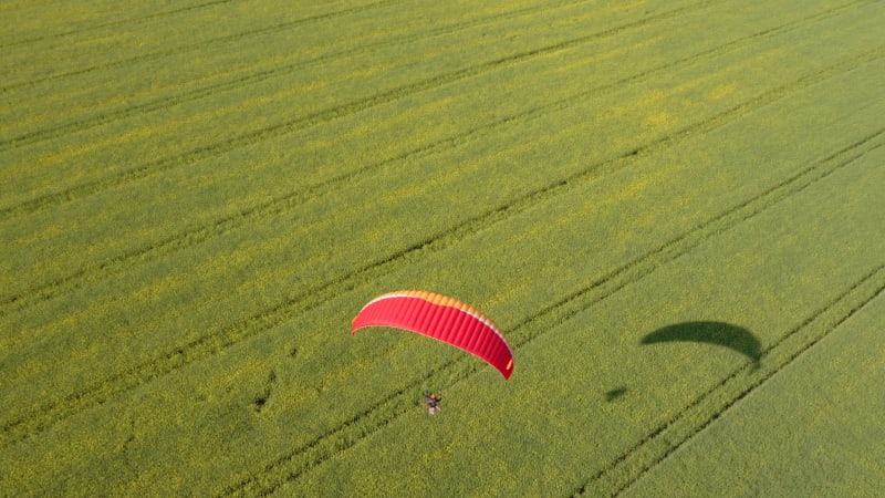 Aerial view of paramotor flying over canola fields, Tekirdag, Turkey.