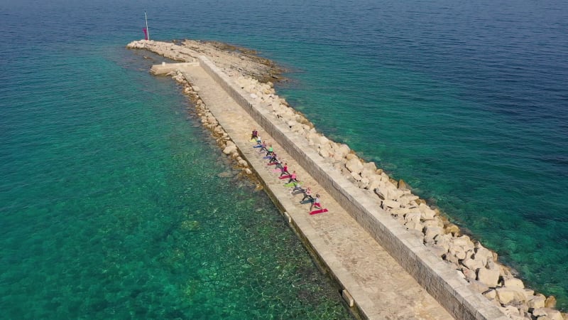 Aerial view of group practicing yoga at artificial pier, Veli Lošinj.