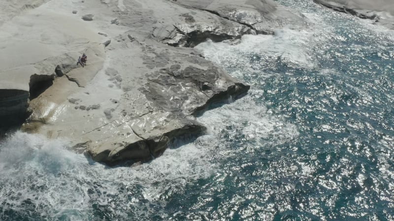 Aerial View of Sarakiniko Lunar Volcanic Beach with Waves crashing into rocks in Milos, Greece