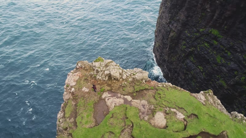 Aerial view of woman walking on the edge of tourists English Slave cliff.
