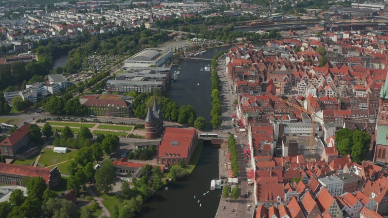 Tilt up a pan reveal of city. Historic red brick buildings in old town separated by river from other neighbourhoods. Luebeck, Schleswig-Holstein, Germany