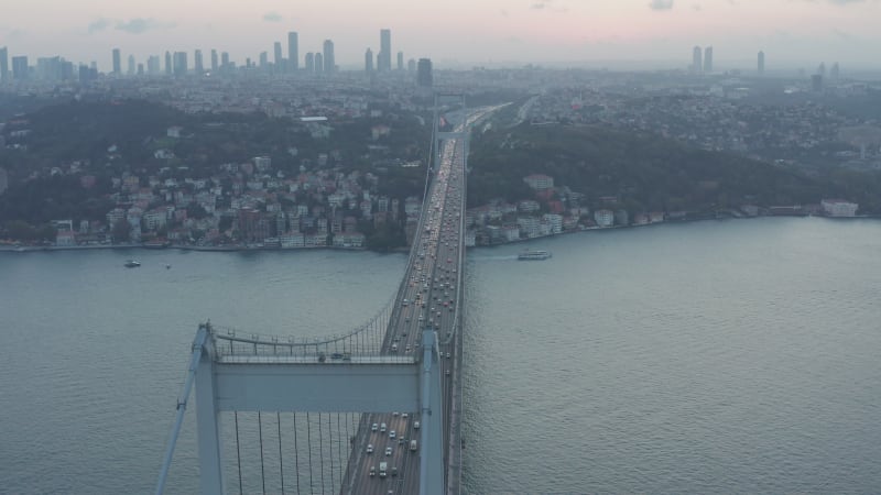 Big Bridge leading into the City Skyline, Car traffic at Sunset in Istanbul, Aerial Dolly Slide left