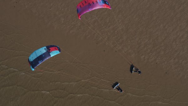 Top-Down Shot of Colorful Kites Flying Over The Beach