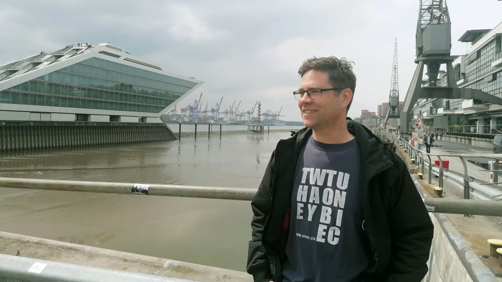 A person stands at Hamburg harbour, opposite Dockland.
