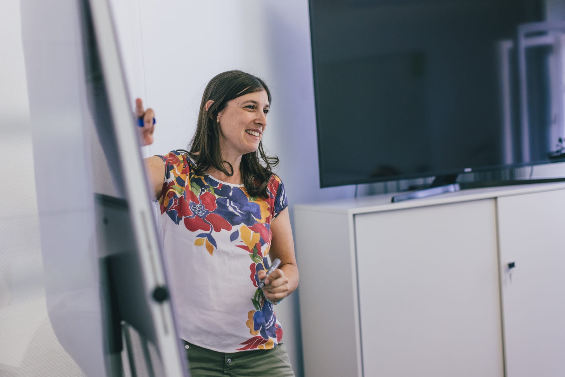 The picture shows SAP application architect Patricia Gomez during a presentation. She is using a FlipChart board.