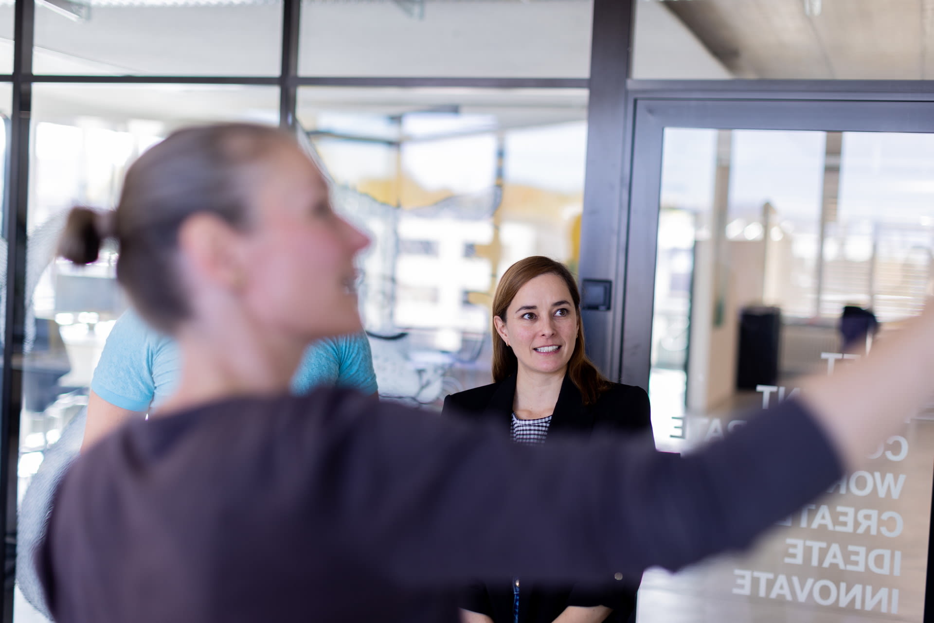 Eine Frau erklärt weiteren Personen etwas.