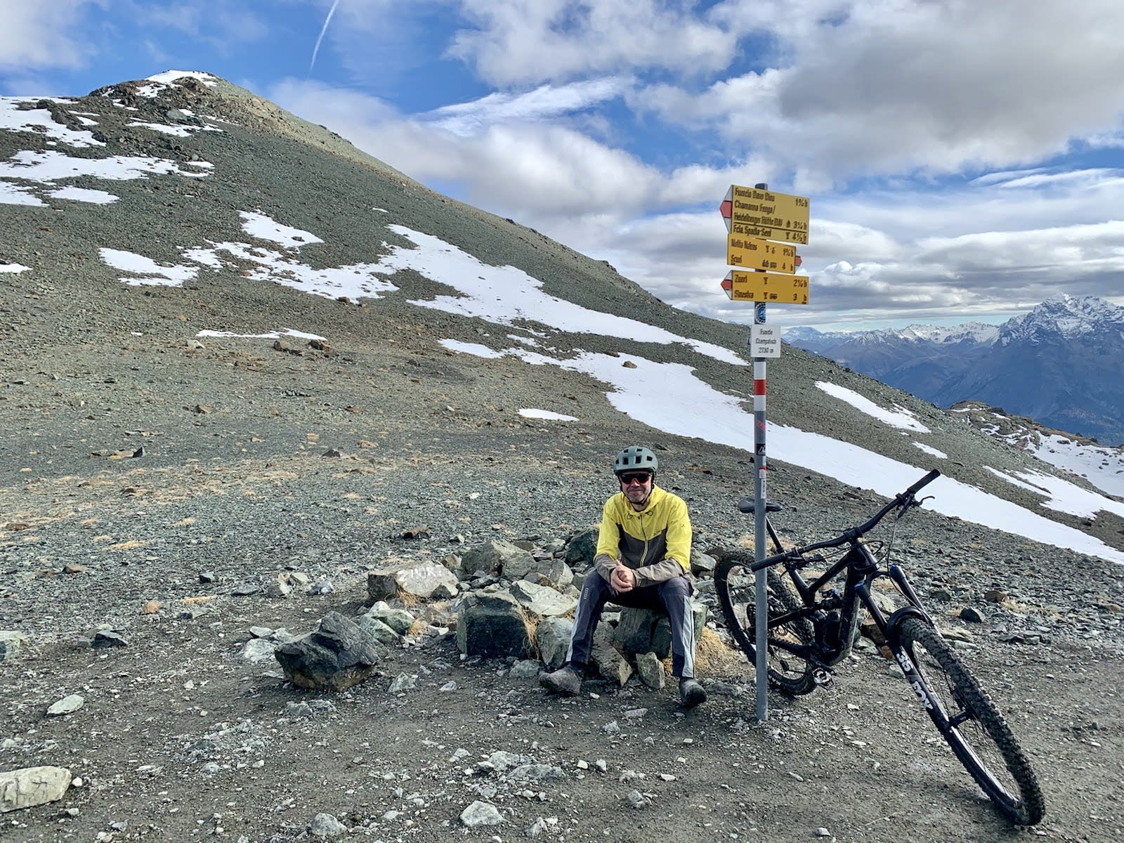 Sandro Dönni mit seinem Bike auf einem etwas leicht verschneiten Berggipfel.