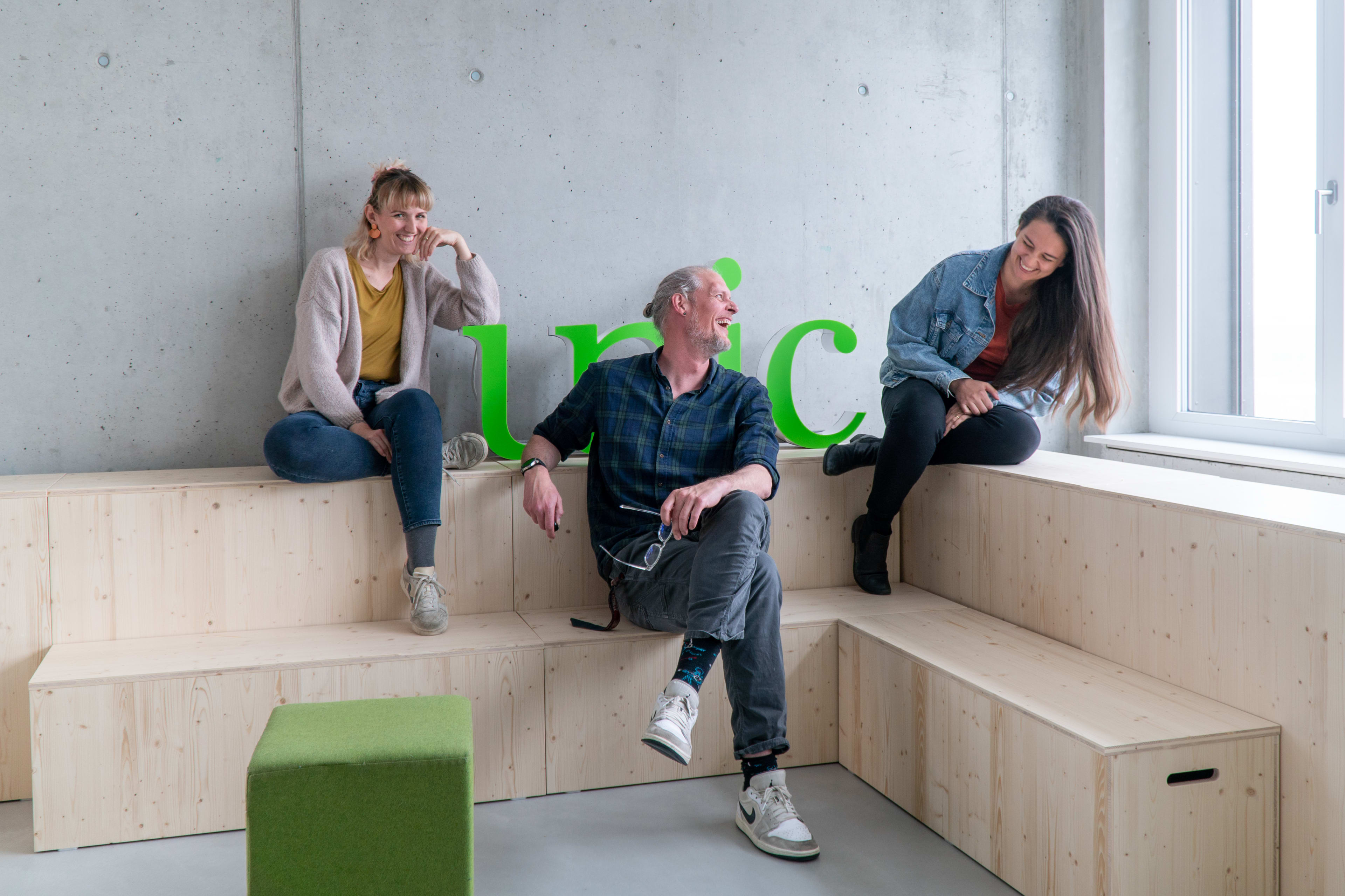 Das Bild zeigt das fröhliche Organisationsteam, welches sich um den Umzug ins Berner Office kümmerte. Es besteht aus zwei Frauen und einen Mann.