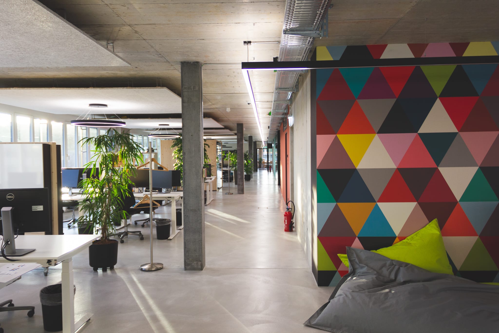 Open-plan office - a wide open corridor to the front, with workstations to the left.