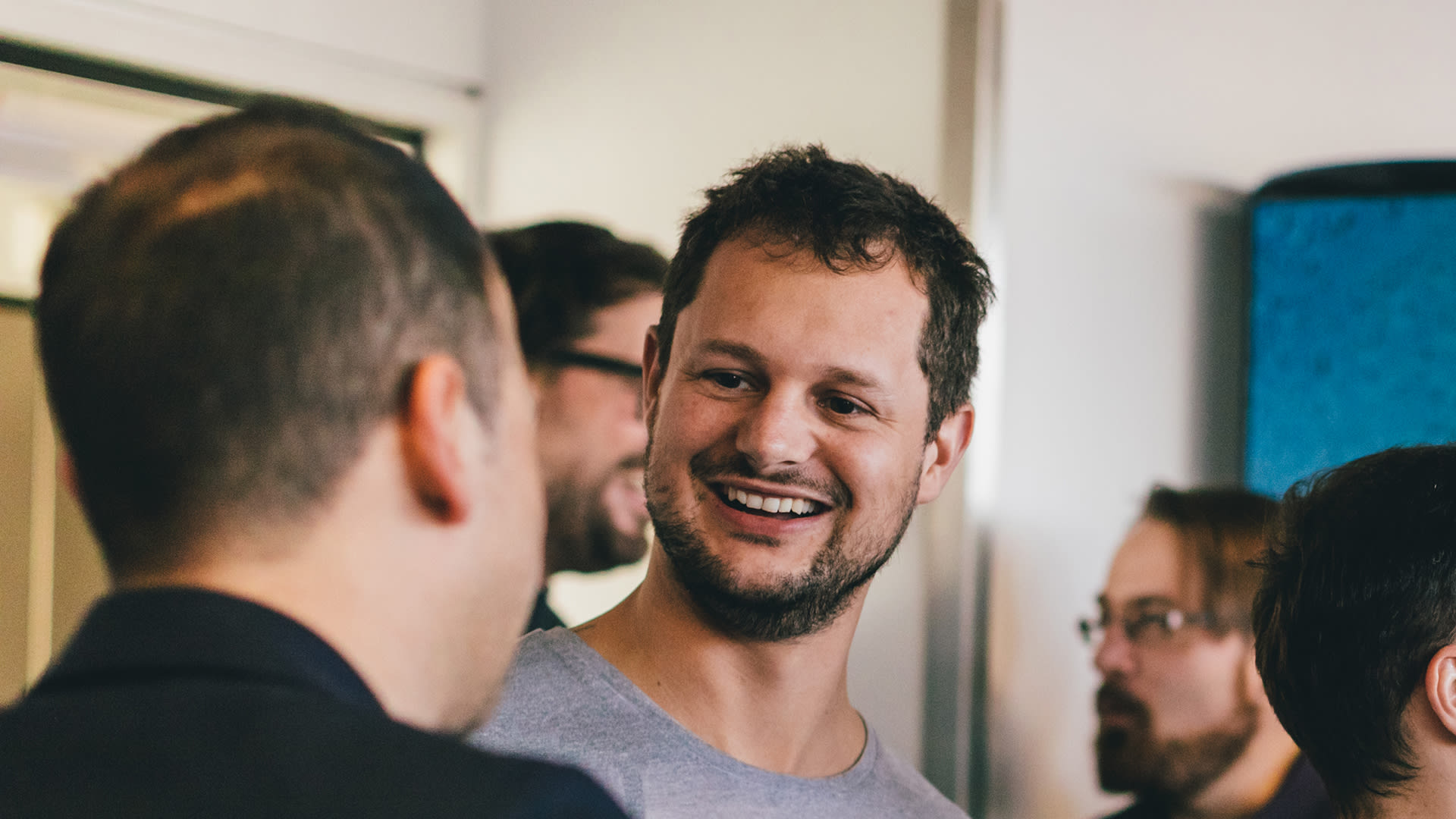 The picture shows a Unic employee talking to another colleague. Other people are recognisable in the background.