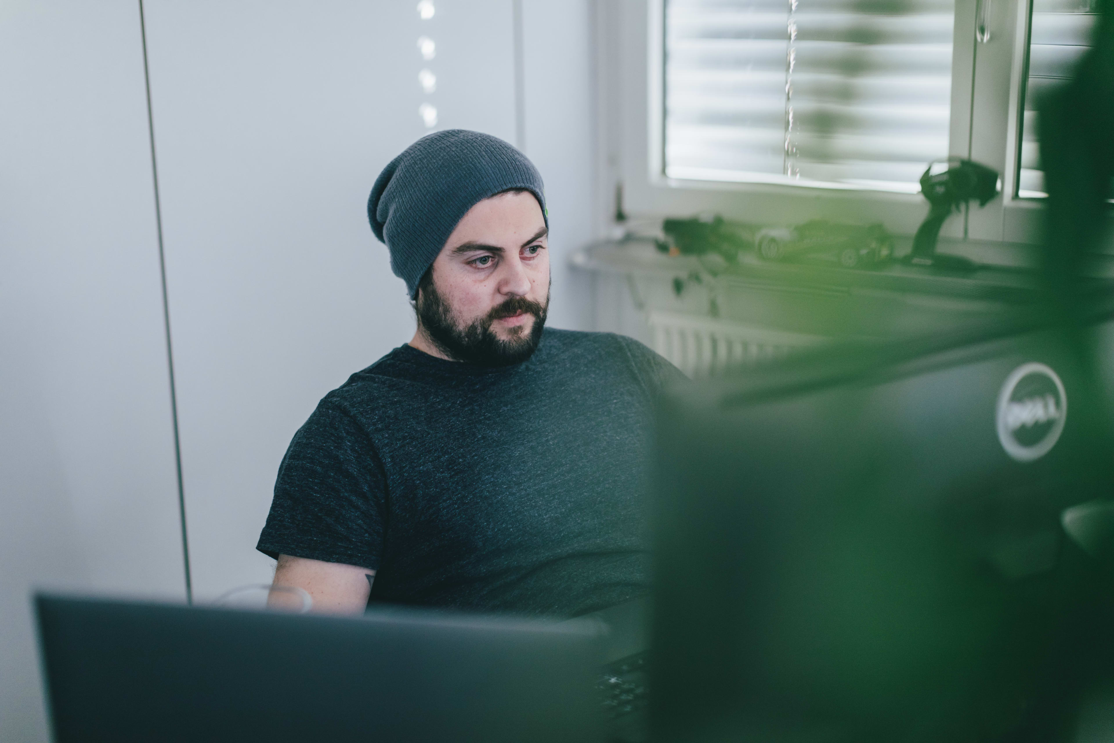 The picture shows Sitecore specialist Tobias Studer sitting in front of two screens, developing code for Unic.