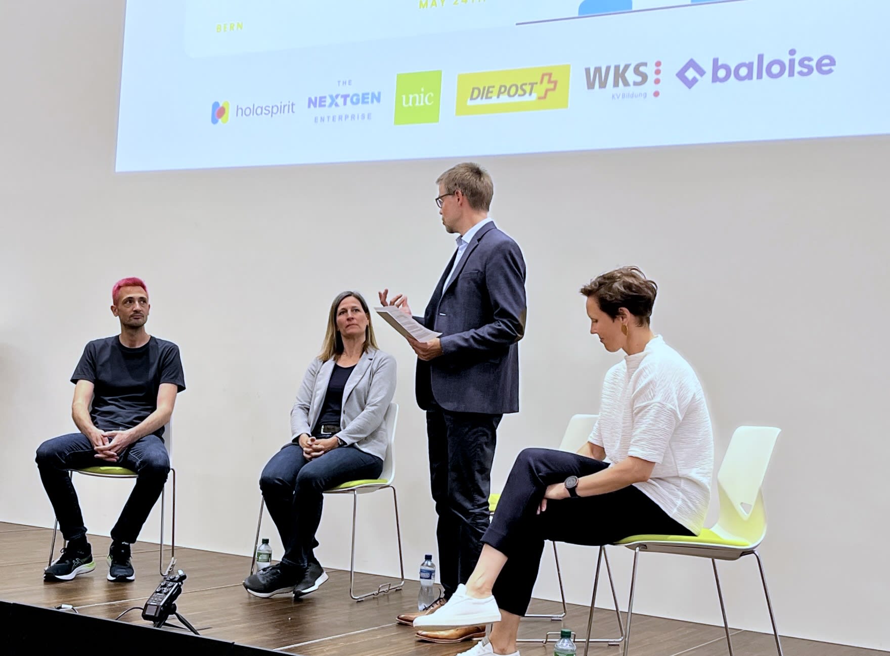 Das Bild zeigt eine Podiumsdiskussion mit insgesamt 4 Personen. Das Thema ist unter anderem NewWork.