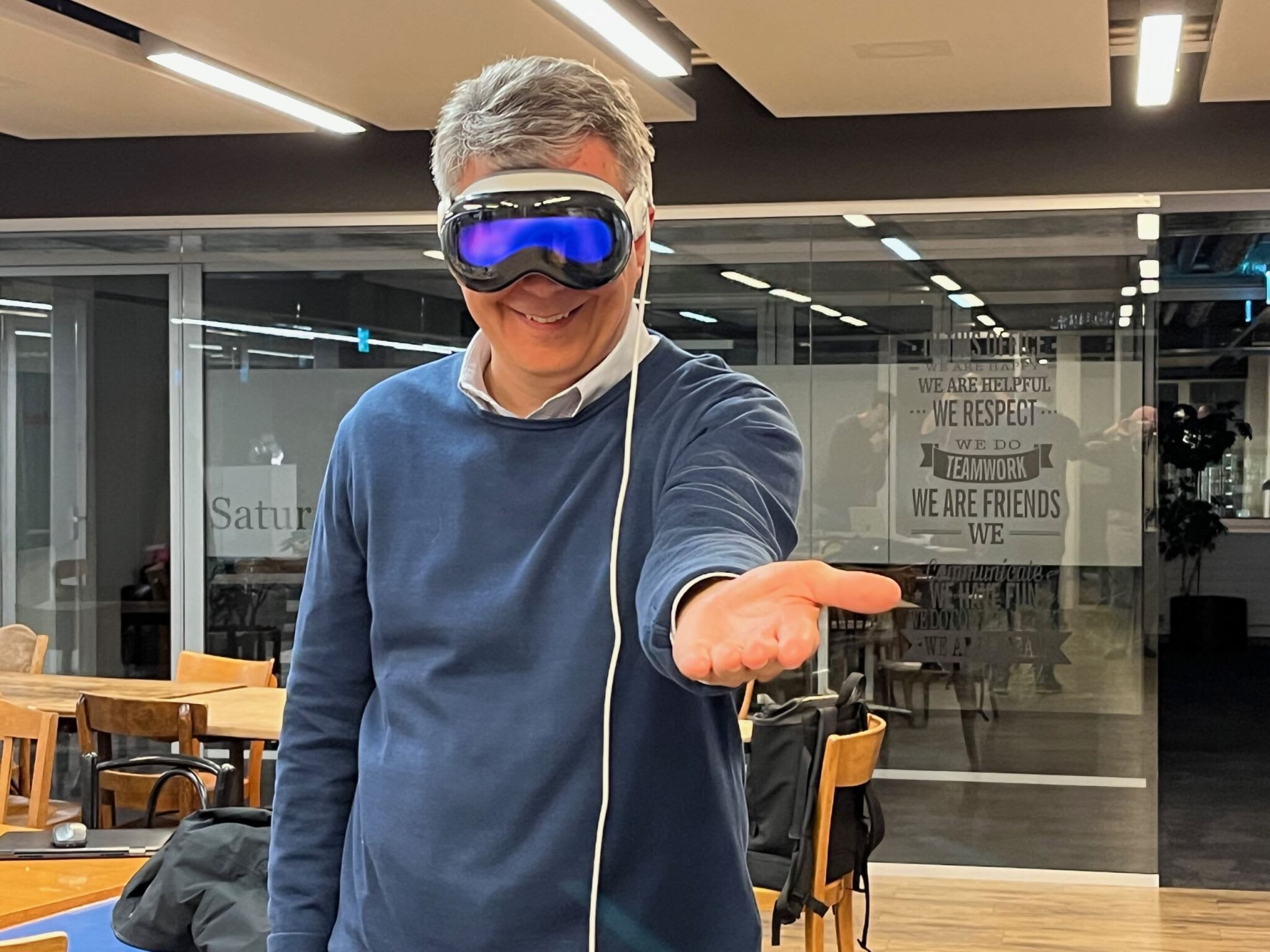 Unic Partner Markus Haschka streckt lächelnd seine Hand in Richtung Kamera. Er trägt dabei die Apple Vision Pro.