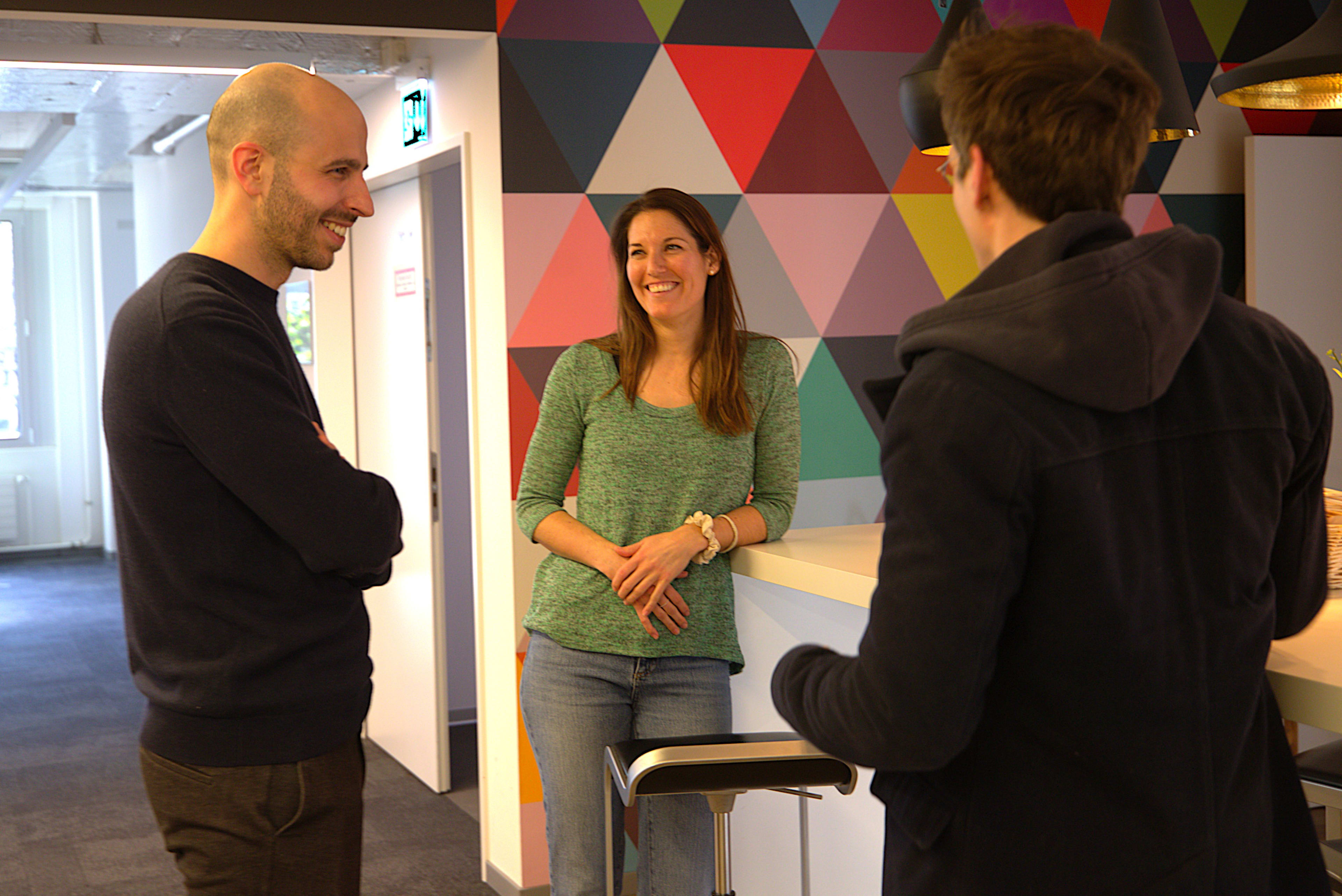 Three people are talking in the Unic office in Zurich.