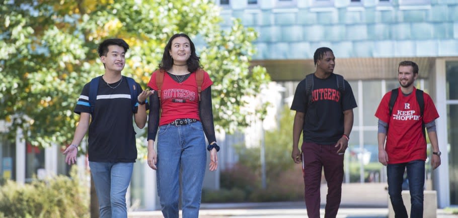 Image of students on campus,  two with with Rutgers University shirts on