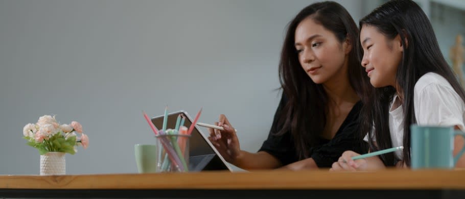 A parent with their child watching a university webinar