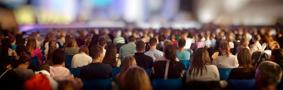 Image of a large audience at a welcome talk at a large exhibition