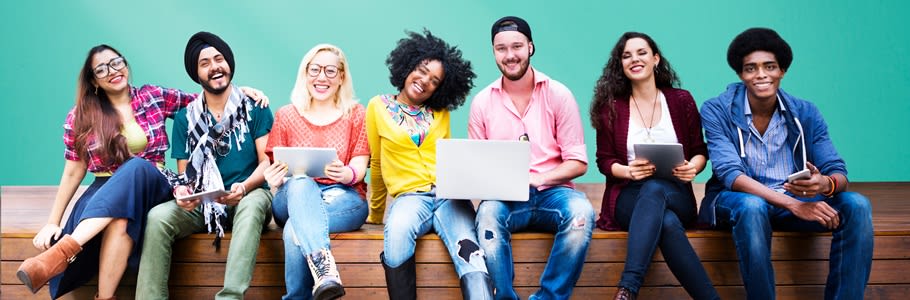 A row of happy, diverse students sat on a bench.