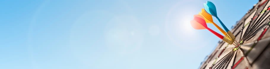 Image of a dartboard, with three darts hitting the bullseye