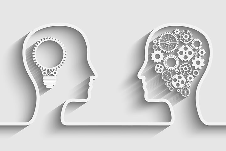 Dvi profilinės galvutės pagamintos iš popieriaus: viena su elektros lempute kaip smegenys, kita su krumpliaračiais, simbolizuojančiais žinias ir mechaninį mąstymą.