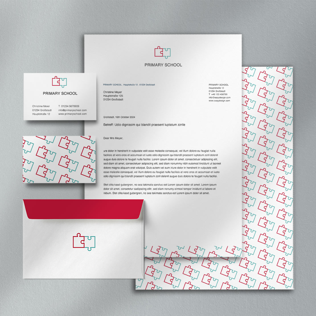 Bransjeflis for utdanning, skoler og barnepass: Brevpapirdesign for en barneskole med en logo med to sammenlåsende puslespillbrikker. Inkluderer visittkort, skrivesaker og konvolutt med geometrisk mønster.