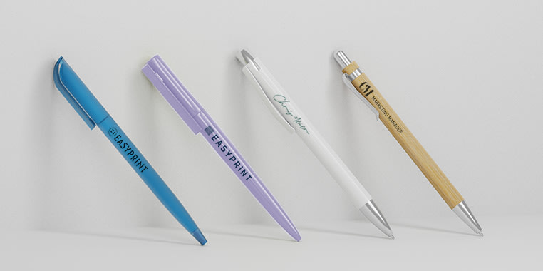 Fire kulepenner i blått, lilla, hvitt og tre ser oppstilt ved siden av hverandre, merket med personlig merkevarebygging, mot en hvit bakgrunn.
