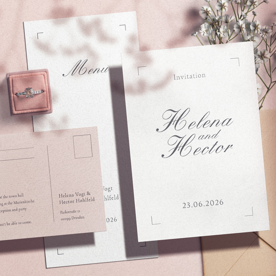 Anlasskachel zum Thema Hochzeit: Einladung und Menü für Hochzeit, daneben rosa Ringbox mit Verlobungsring und zarte Blumen auf rosa Hintergrund.