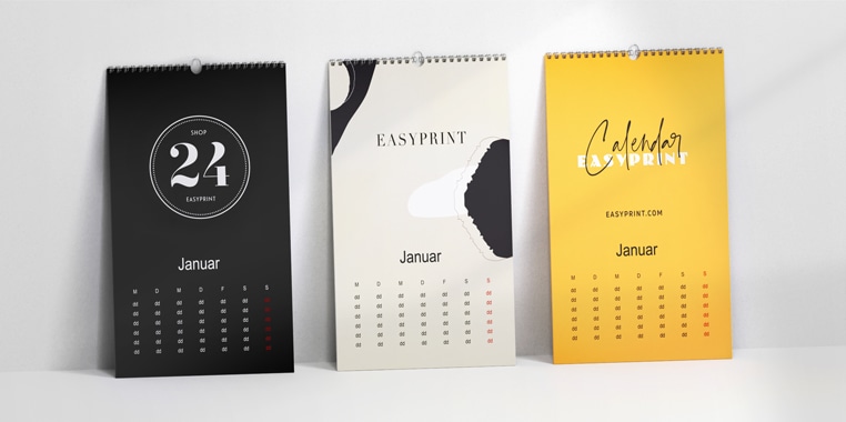 Drei Wandkalender im Infowerk-Design – links in Schwarz mit '24'-Grafik, mittig in Beige mit abstraktem Muster, rechts in Gelb mit 'Calendar'-Schriftzug – moderne Kalendergestaltung für Büro und Zuhause.