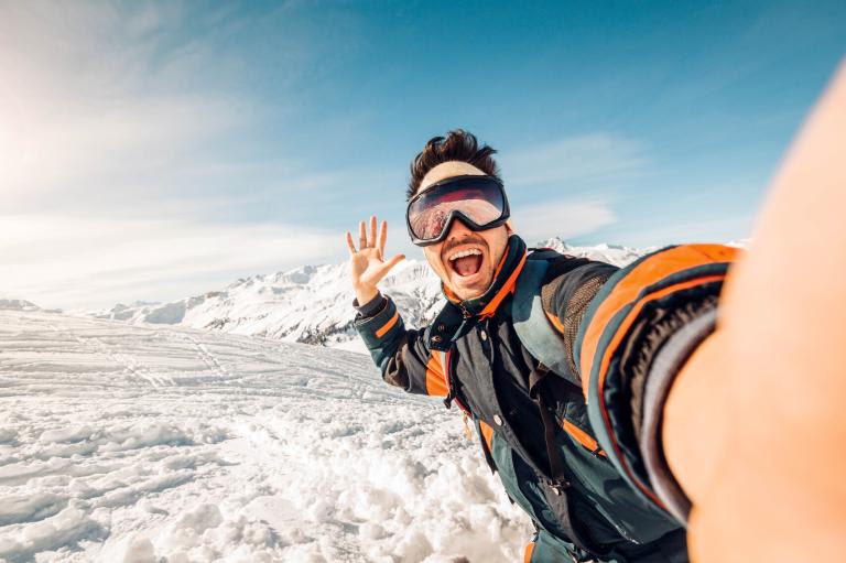 Young guy taking selfie on ski slopes Young guy taking selfie on ski slopes