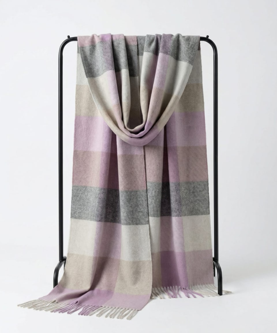 Unisex woven cashmere scarf in check pink, draped over a hanger