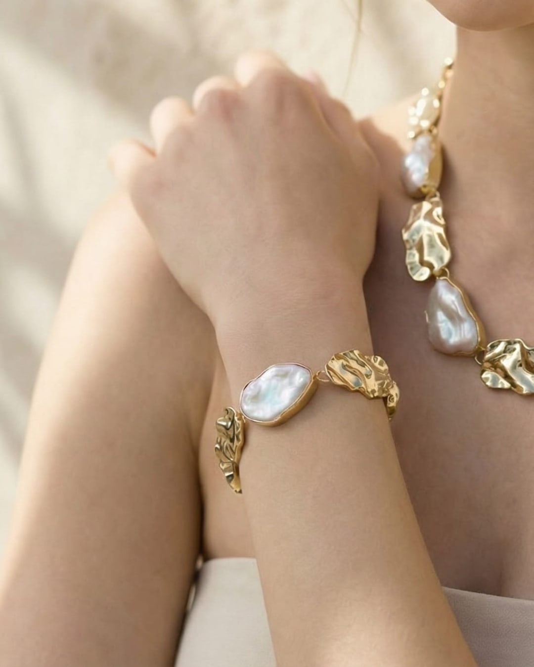 Close-up of Unur keshi pearl statement chain bracelet with gold leaf accents on wrist