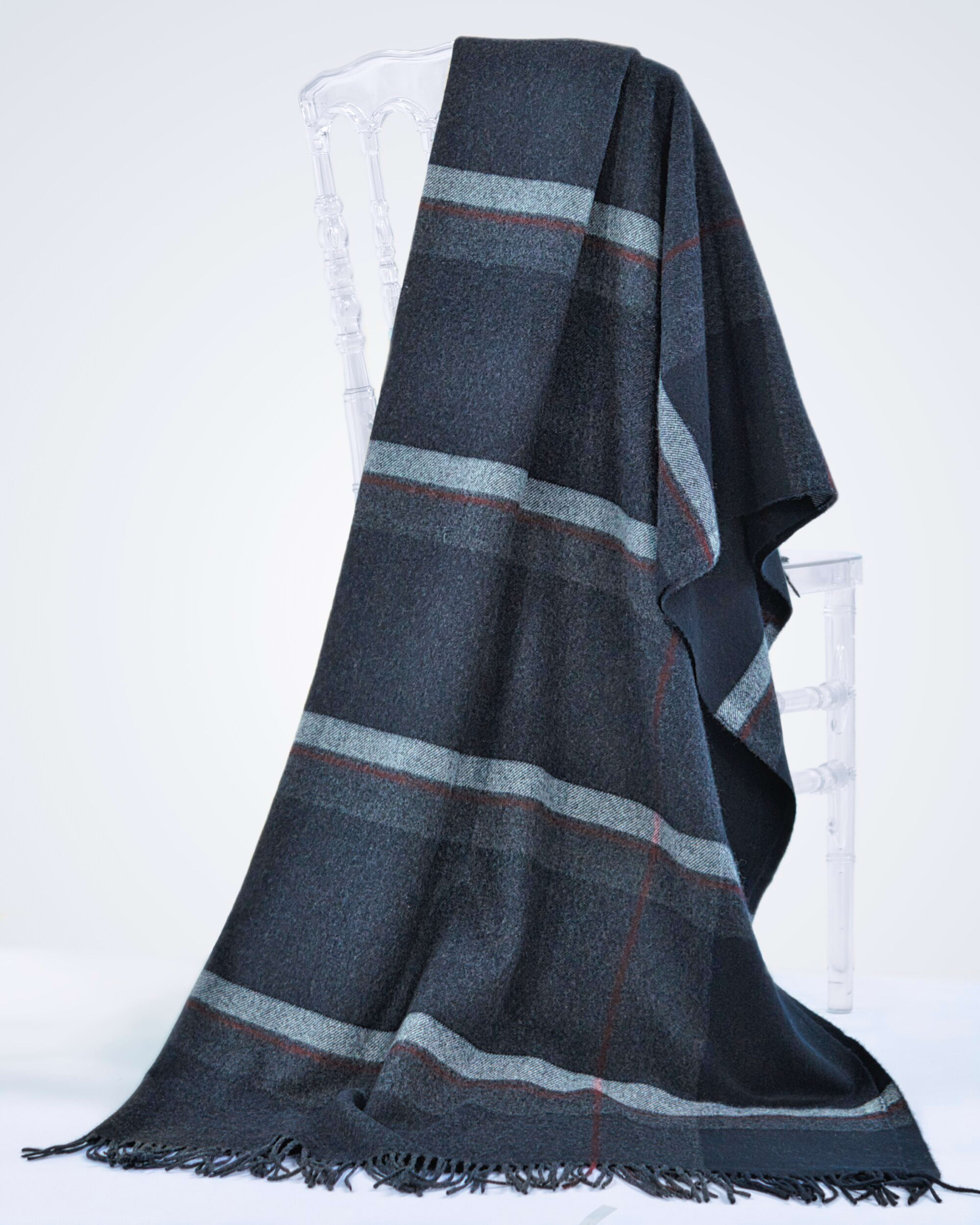 charcoal cashmere blanket with plaid stripes draped over a chair