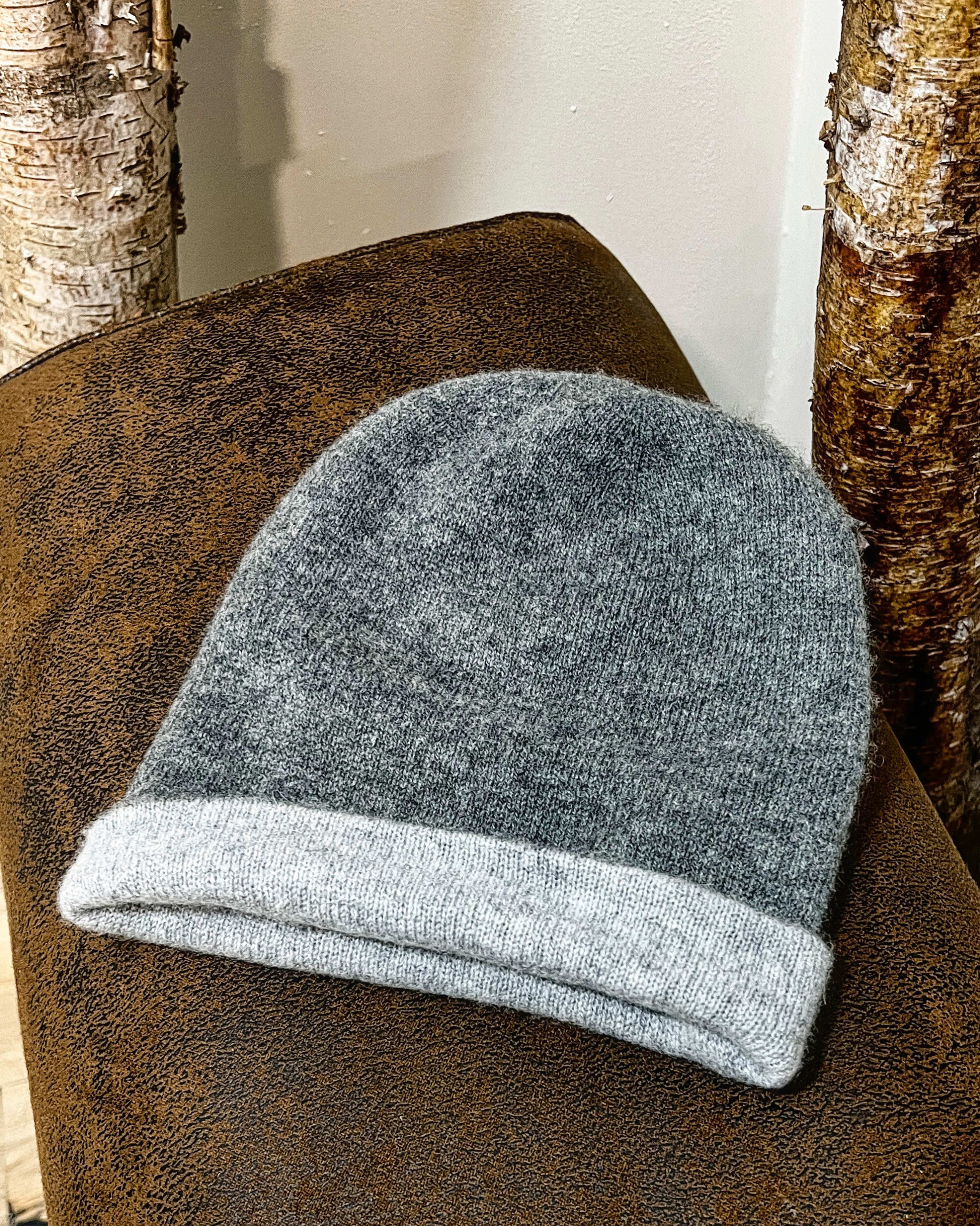 Grey cashmere beanie on neutral background, flat view
