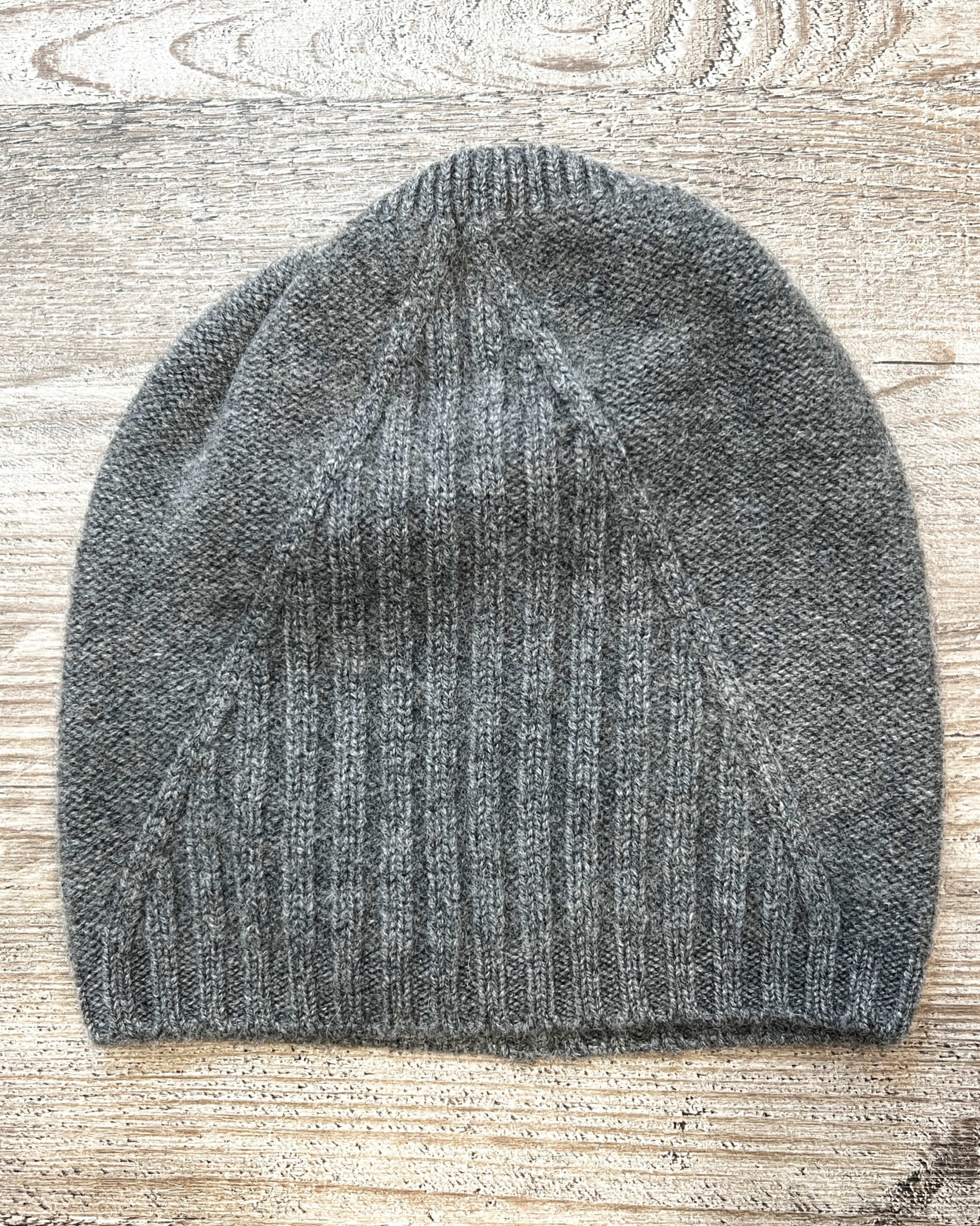 Grey cashmere beanie on neutral background, flat view