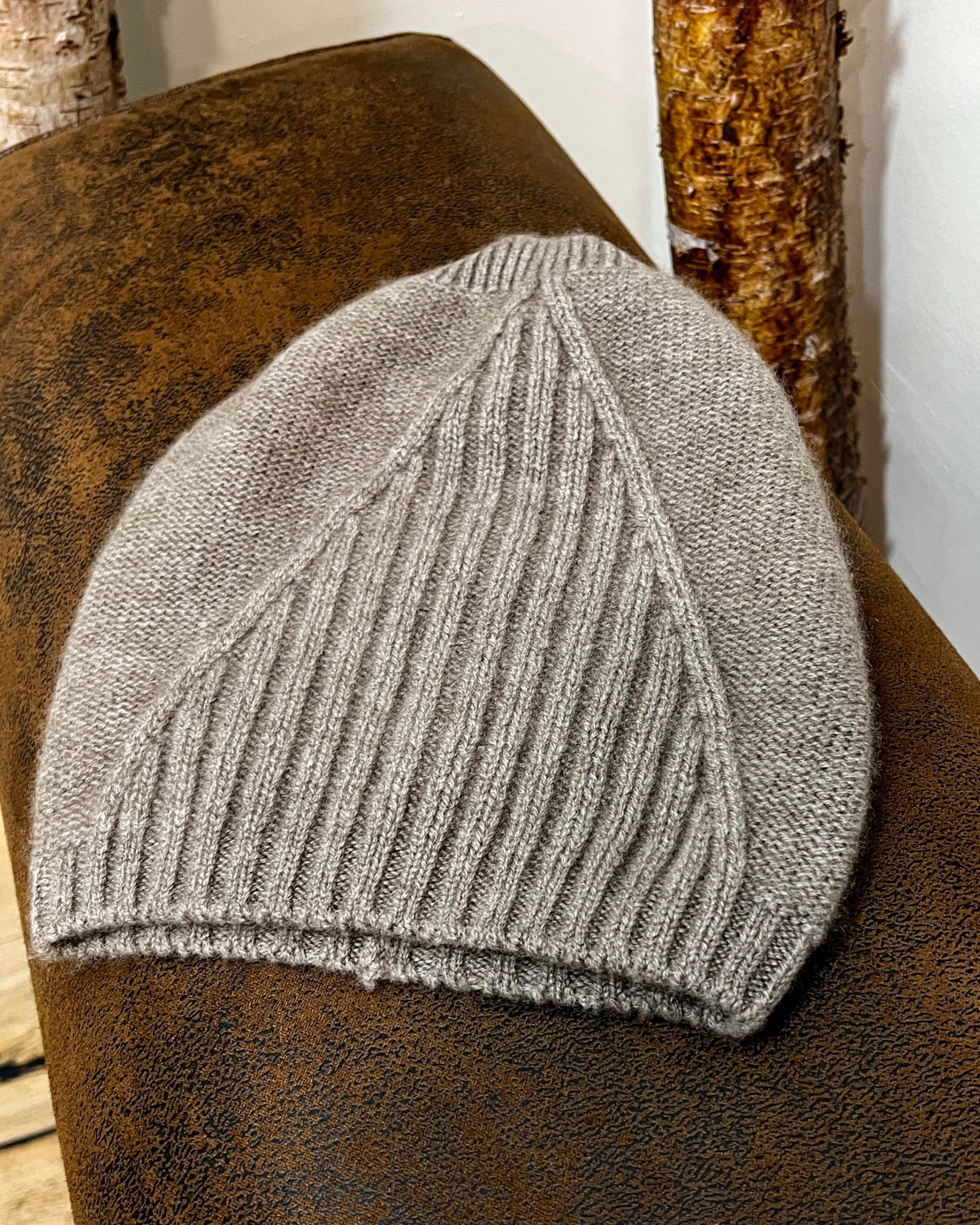 Natural brown cashmere beanie on neutral background, flat view