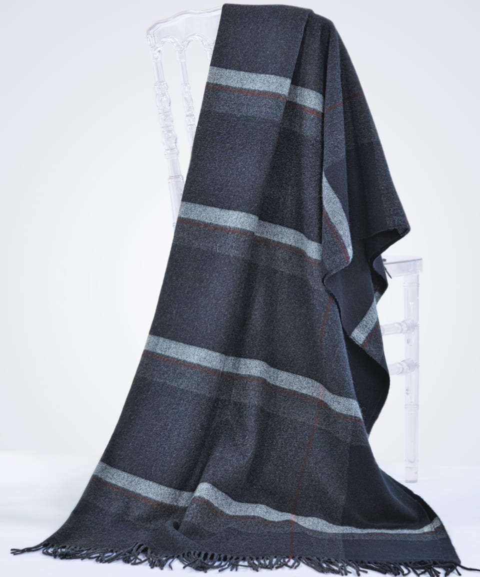 charcoal cashmere blanket with plaid stripes draped over a chair