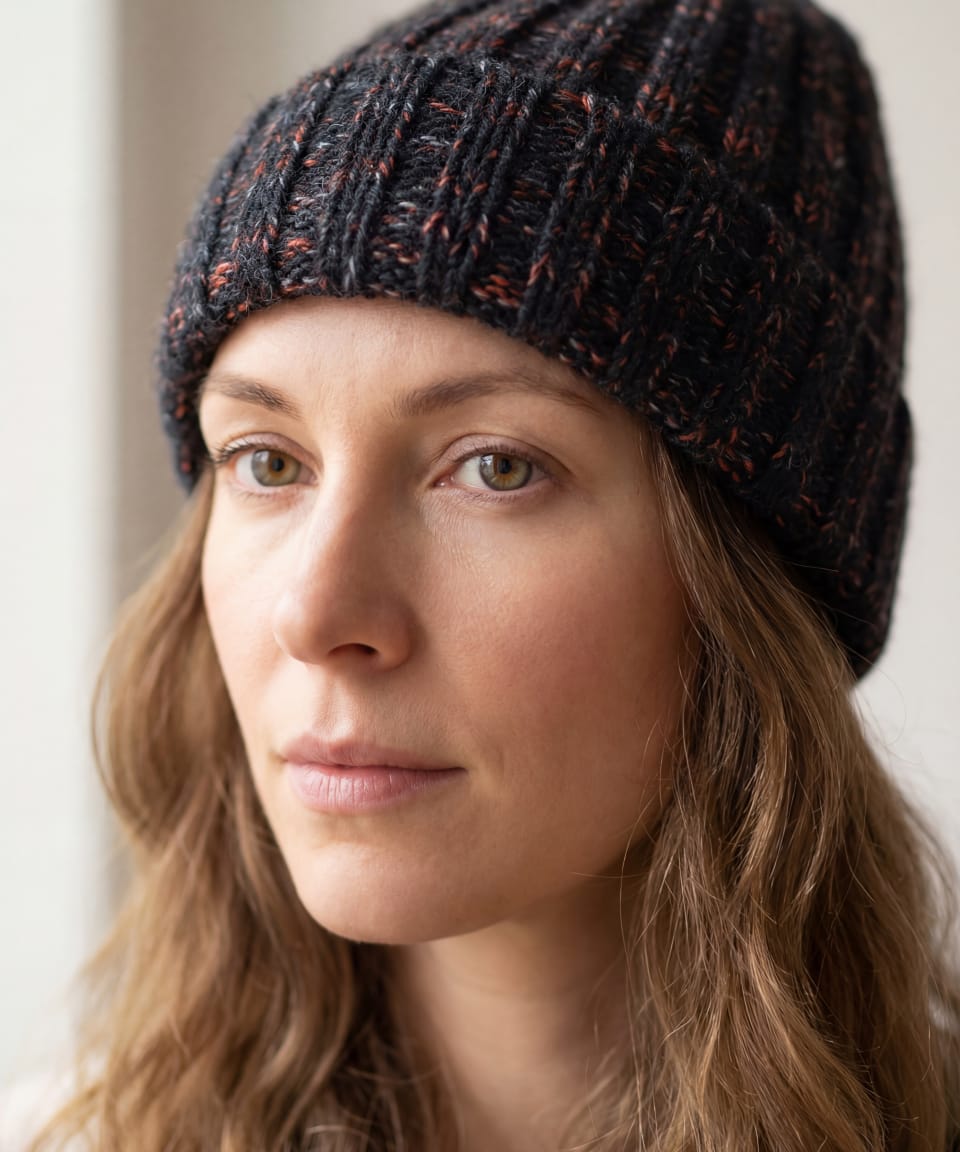Woman wearing chunky ribbed yak wool hat in mottled black and pink