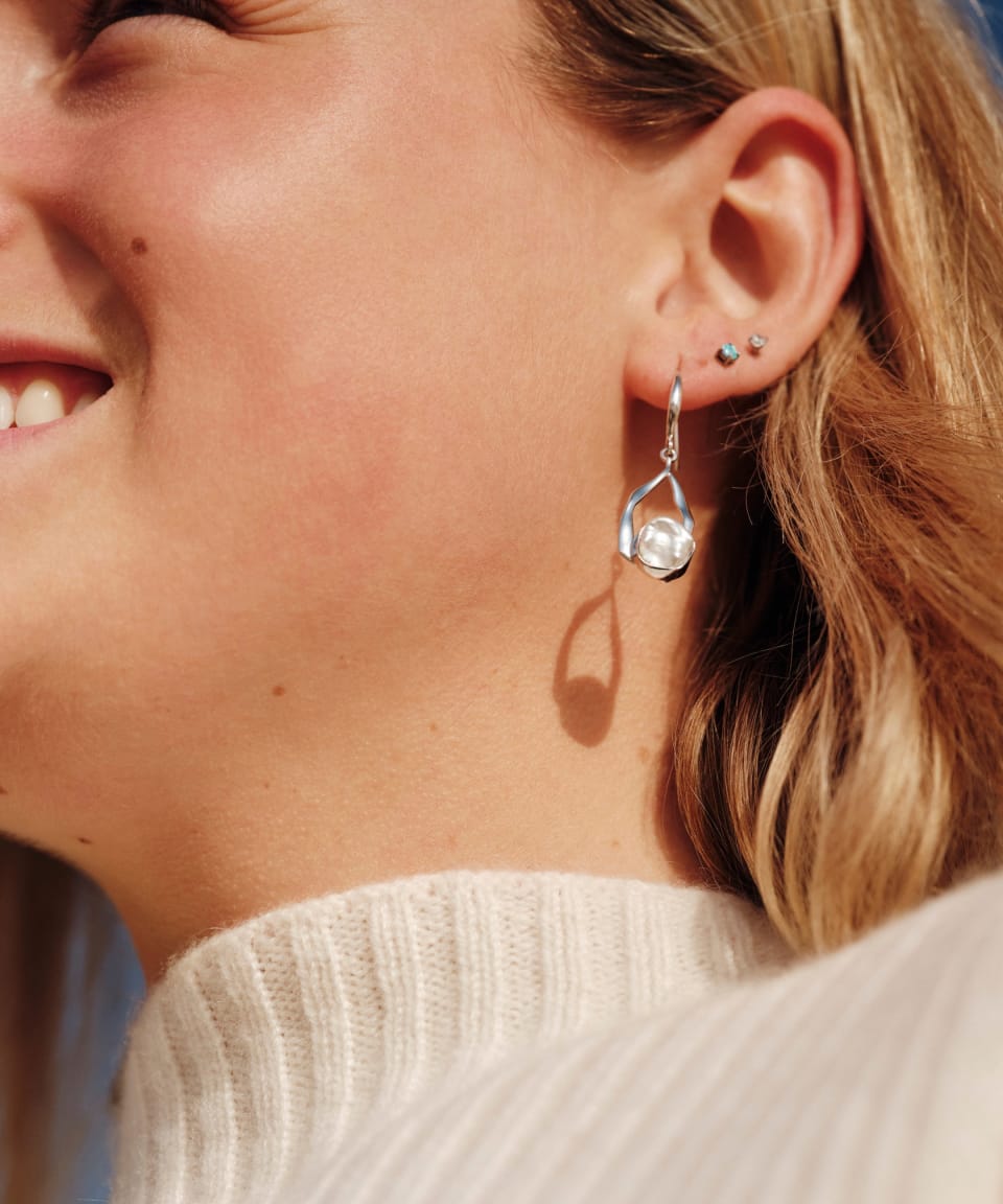 Model wearing classic keshi pearl drop earrings with silver wishbone stem