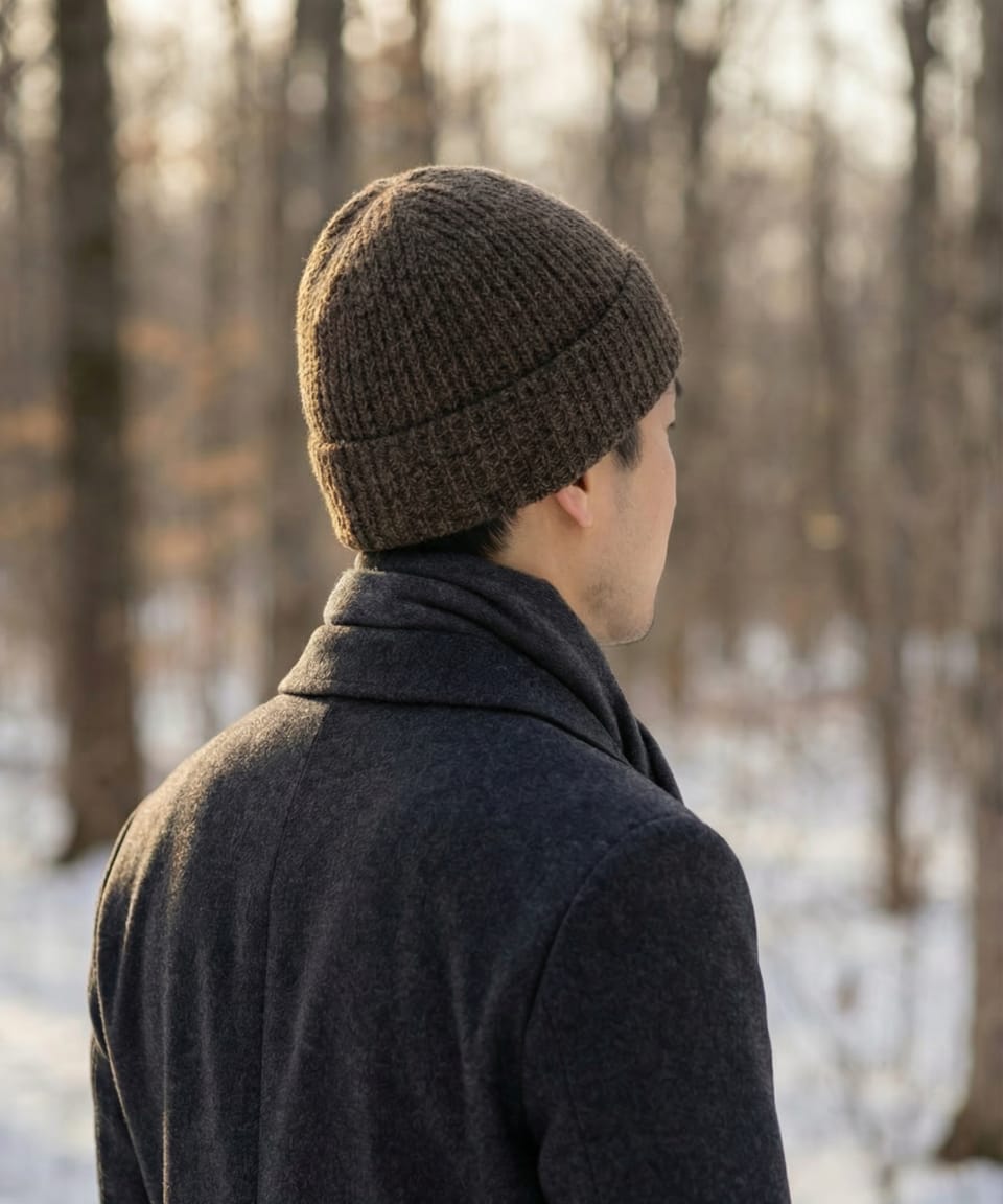 Rear view of man outdoors wearing a unisex ribbed yak wool hat in mottled dark brown