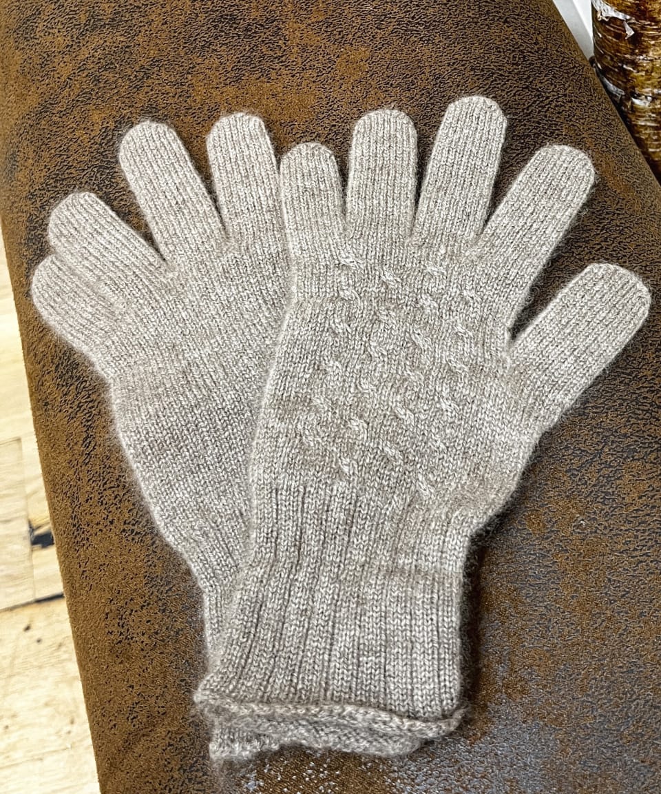 Natural brown cashmere gloves on neutral background, flat view