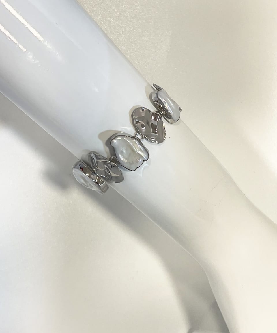 Model wearing signature keshi pearl statement chain bracelet with silver leaves