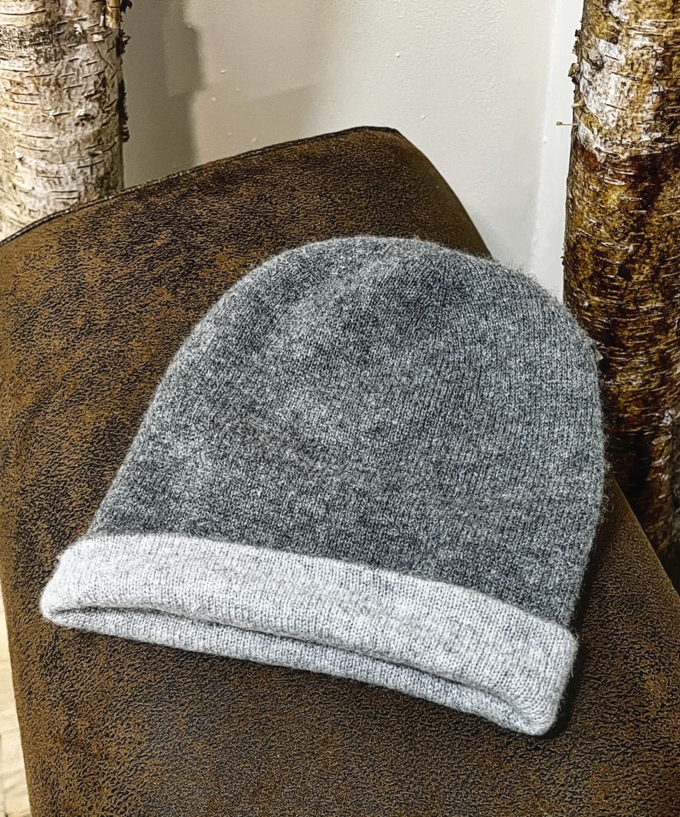 Grey cashmere beanie on neutral background, flat view
