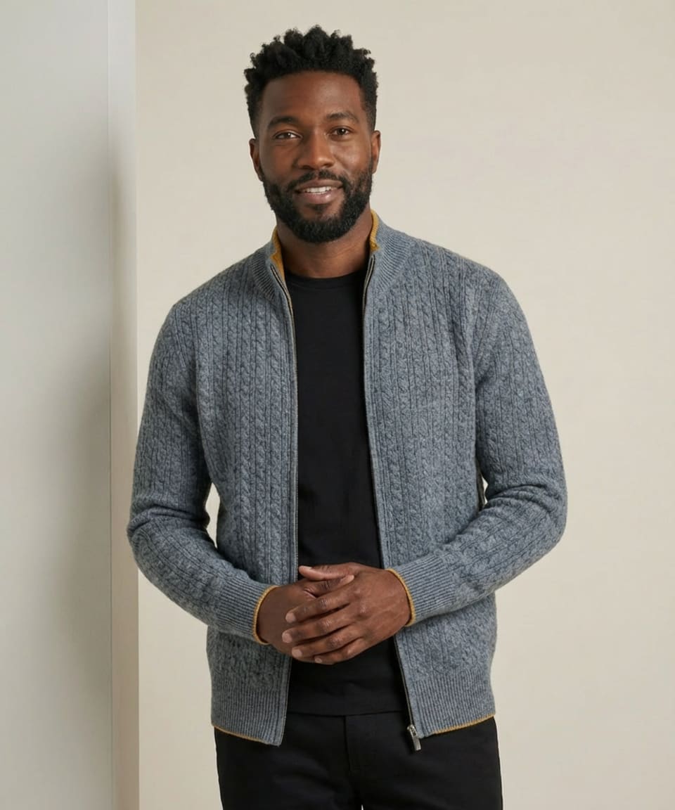 Men's grey cable-knit cashmere zip cardigan with mustard yellow contrast trim and ribbed funnel collar.