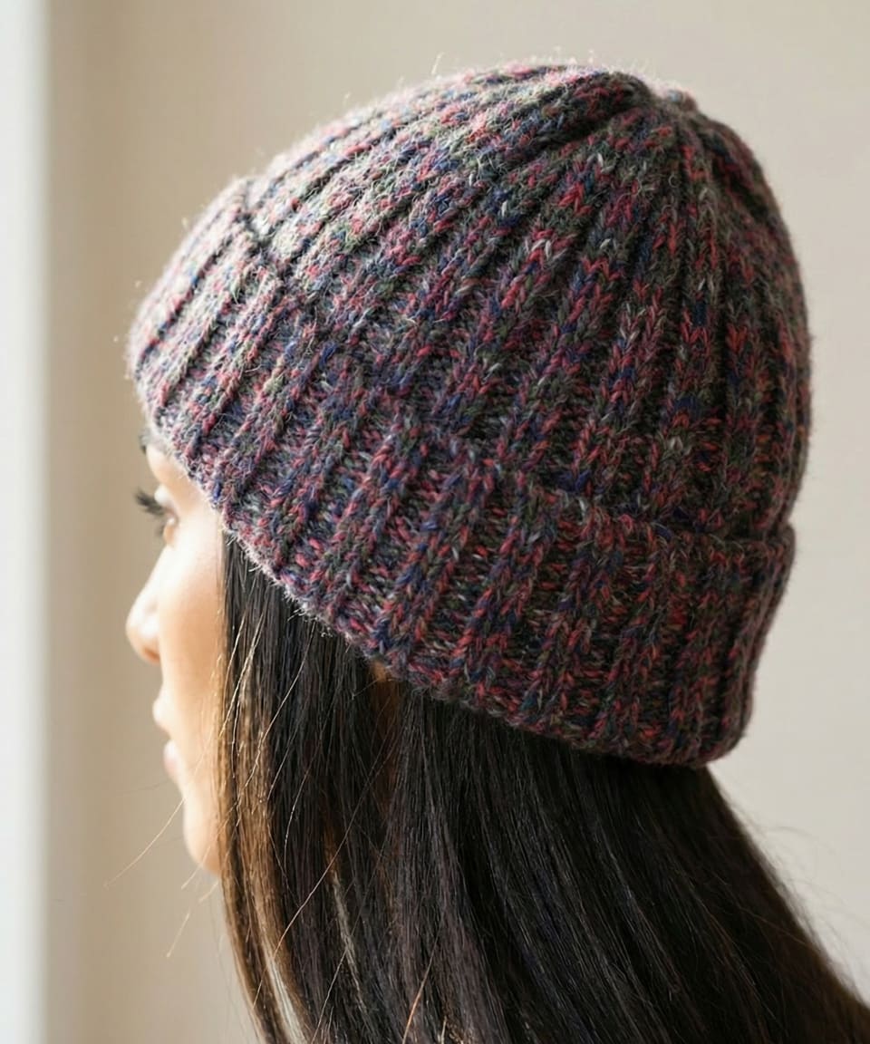 Rear view of woman wearing chunky ribbed yak wool hat in mottled red