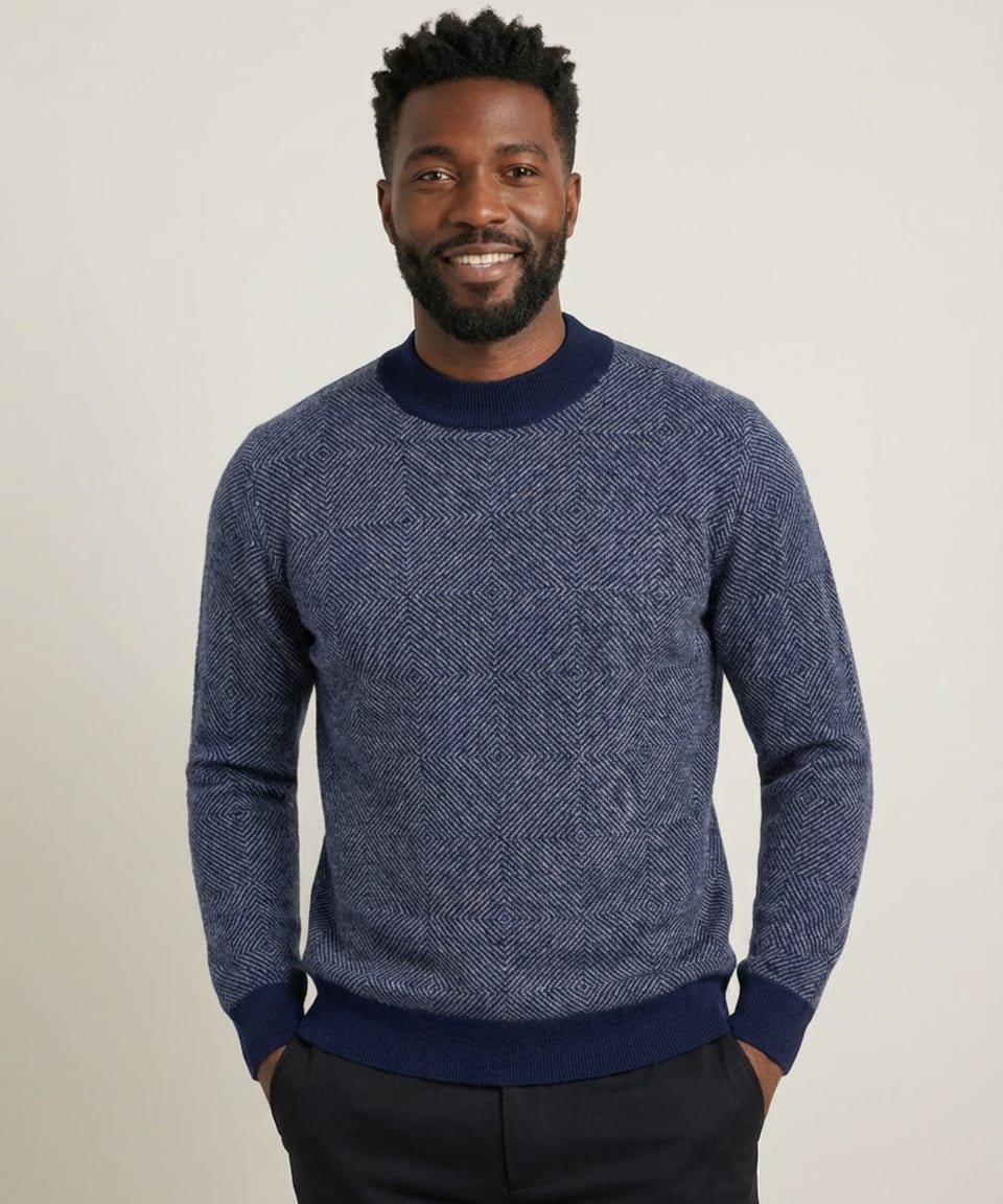 Man wearing a navy cashmere crew neck jumper with concentric diamond jacquard pattern in heather blue and contrasting ribbed trim – Unur