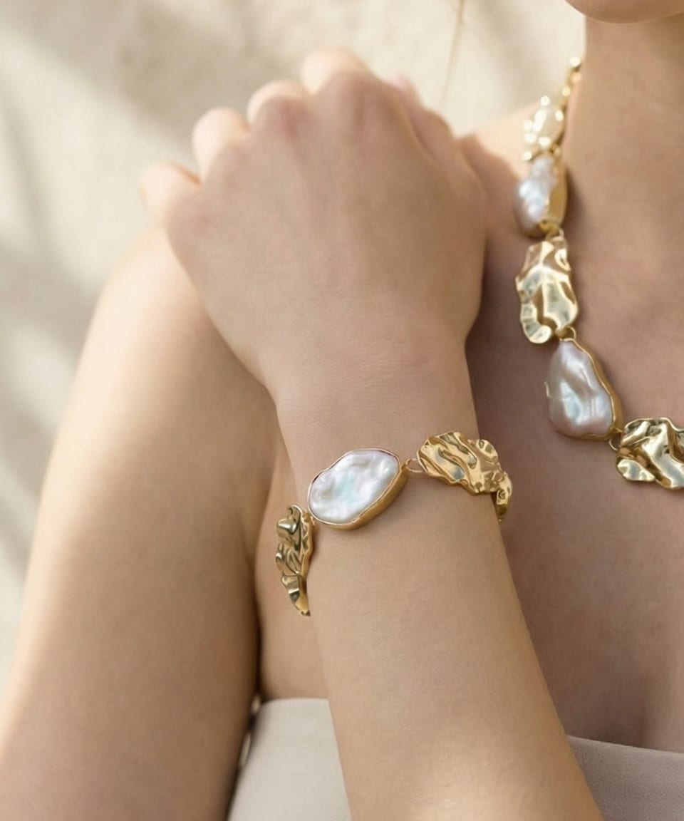 Close-up of Unur keshi pearl statement chain bracelet with gold leaf accents on wrist