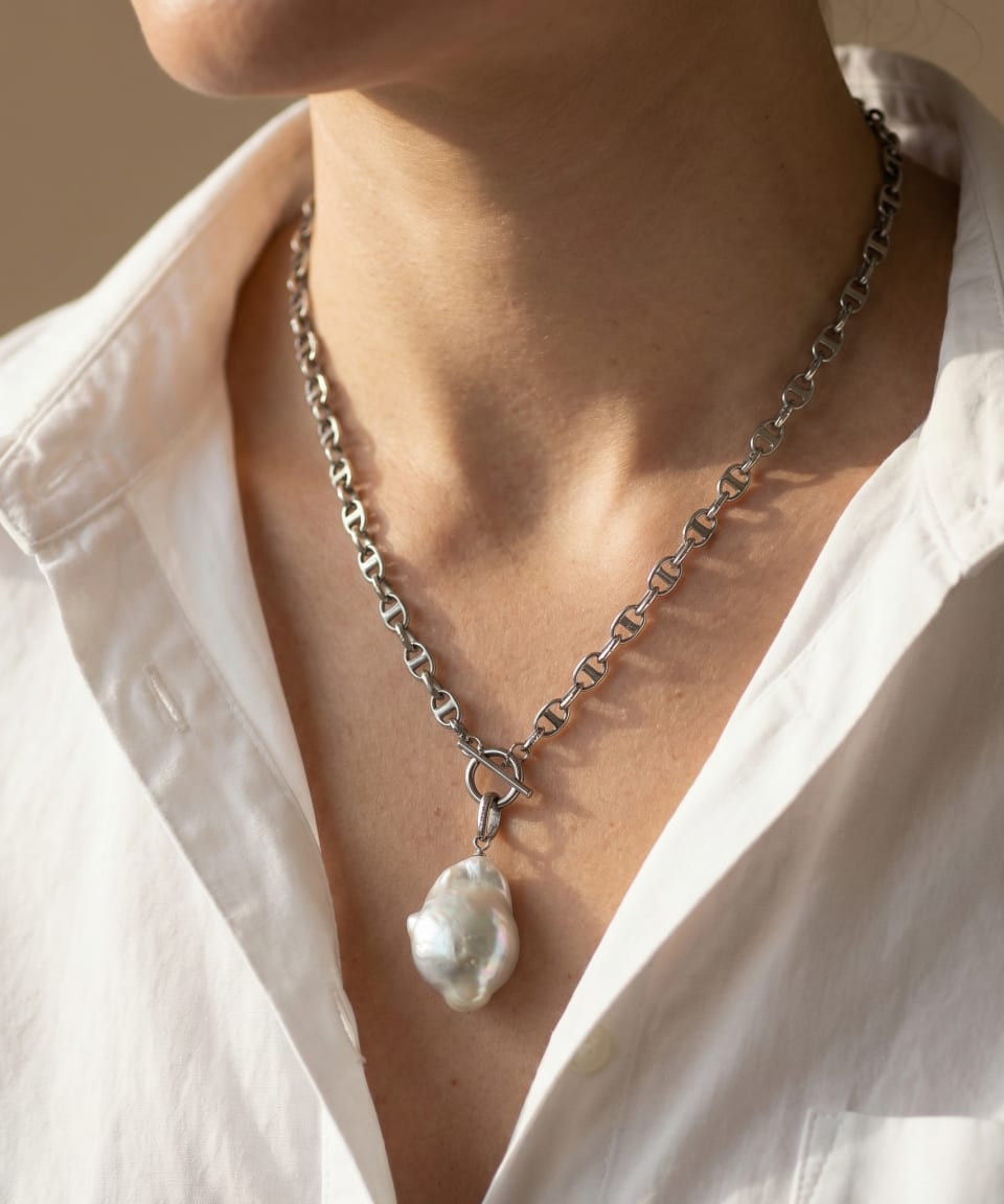 Model wearing the Baroque Pearl pendant necklace on a silver mariner chain, with the toggle clasp at the front.