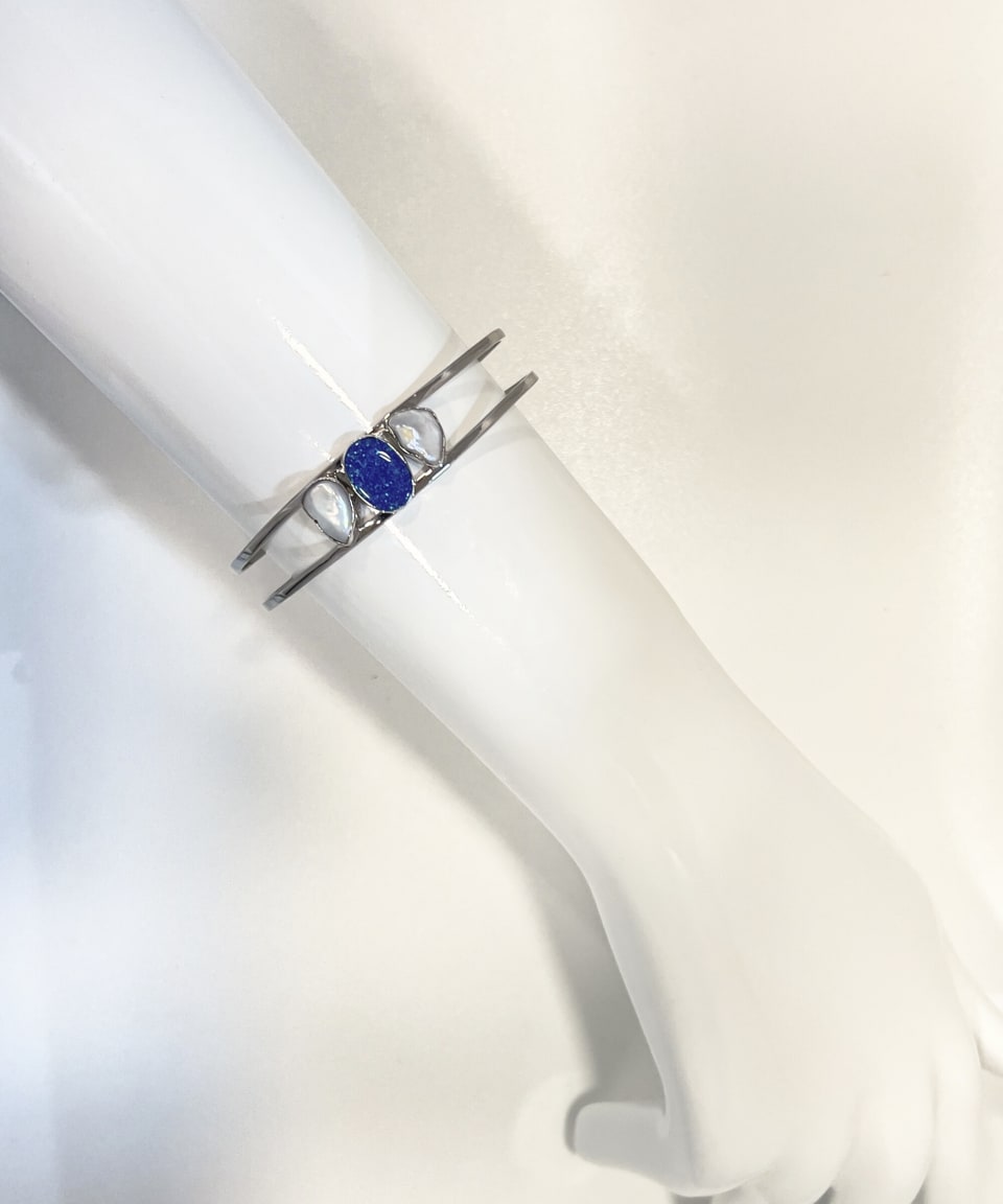 Unur Signature Keshi Cuff Bracelet, mounted product shot showing double-rail silver band with central bezel-set blue opal and two teardrop keshi pearls